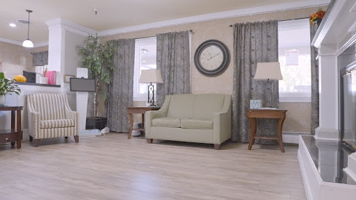 A cozy living room featuring a green sofa, elegant curtains, and stylish decor.