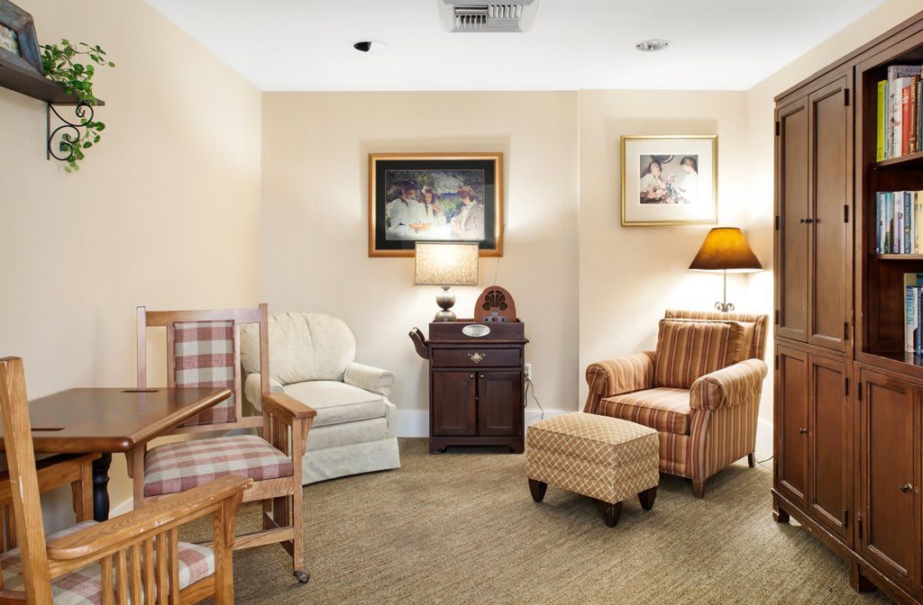 A cozy living room with comfortable armchairs, a sofa, and warm lighting from table lamps.