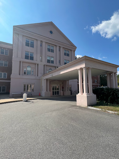 A view of a hotel entrance featuring classical architecture against a clear blue sky.