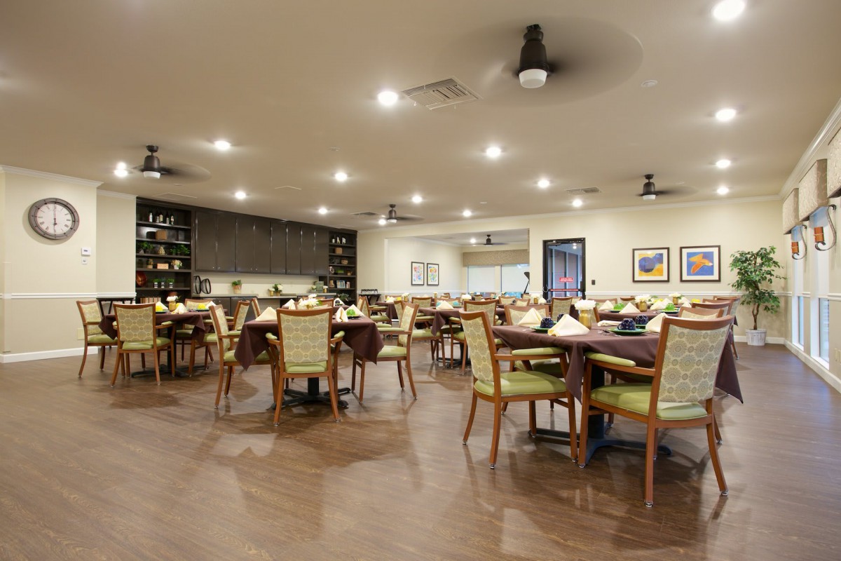 A spacious and elegantly set restaurant dining area with neatly arranged tables and chairs.