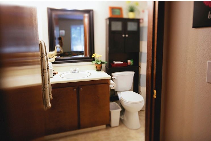 A cozy bathroom with a sink, mirror, and storage cabinet.
