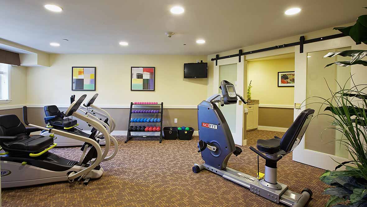 A well-equipped indoor gym with stationary bikes and weights.