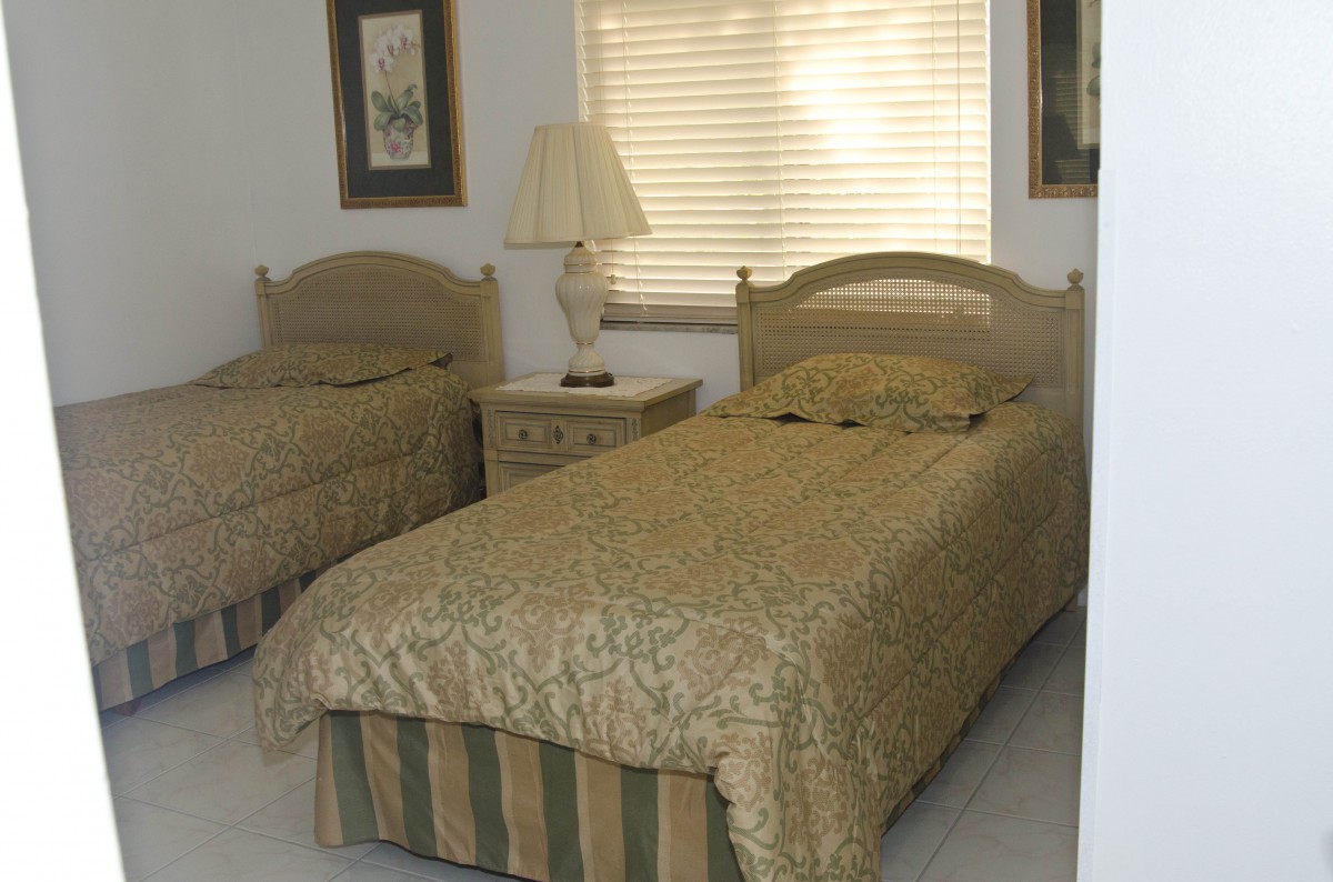 A cozy bedroom with two twin beds and a nightstand between them.