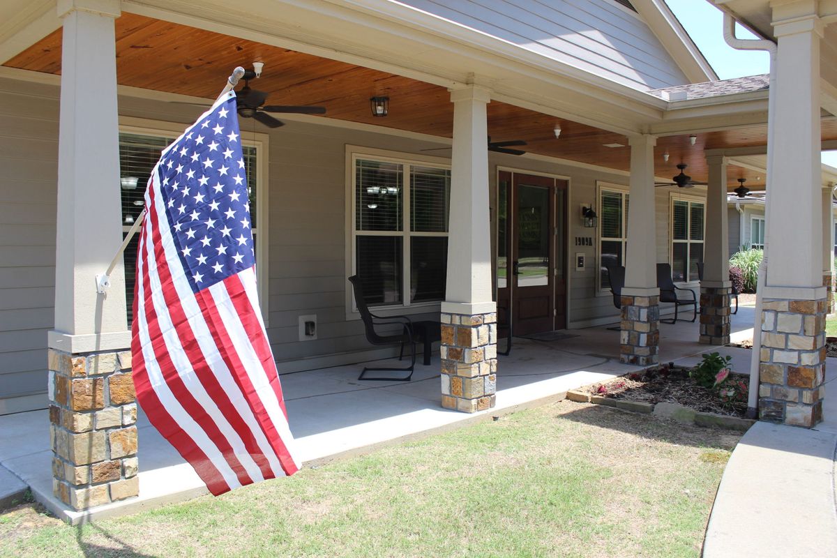 A porch with an American flag and outdoor seating area.