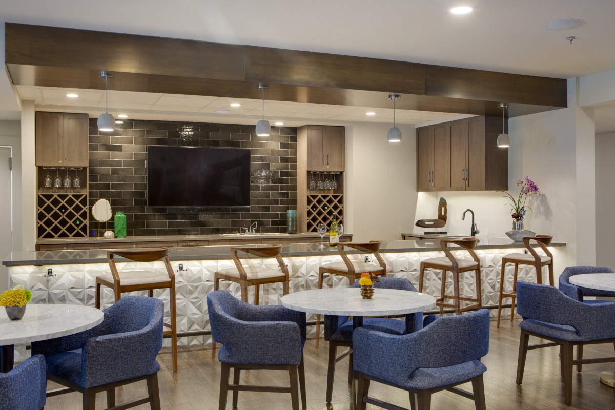 A modern kitchen with a sleek bar area and comfortable seating.