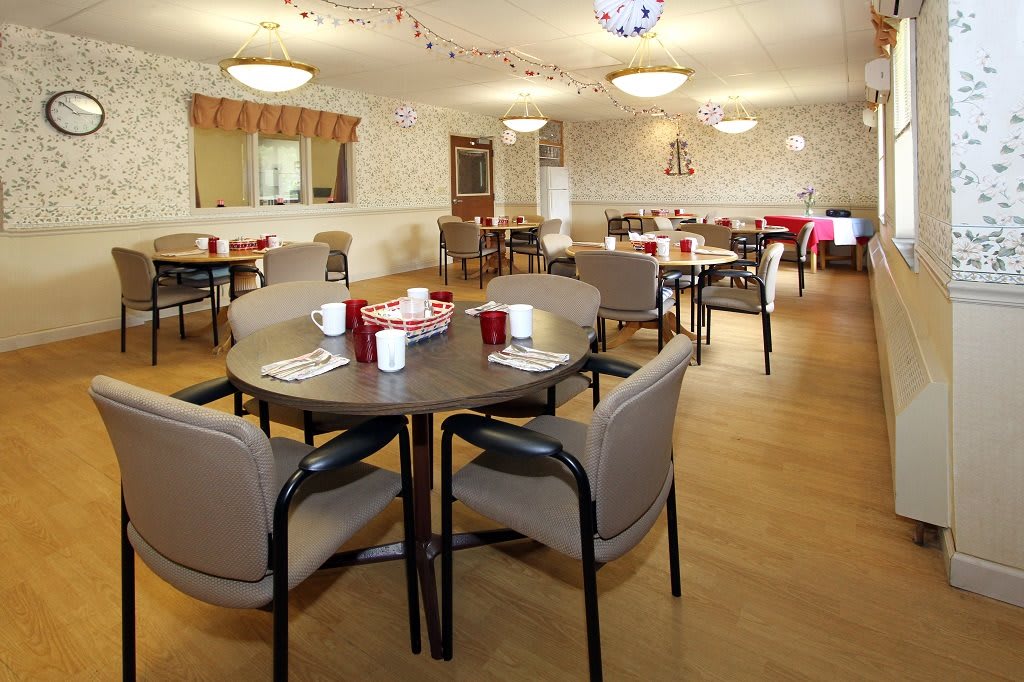A spacious dining area with neatly arranged tables and chairs, ready for guests.