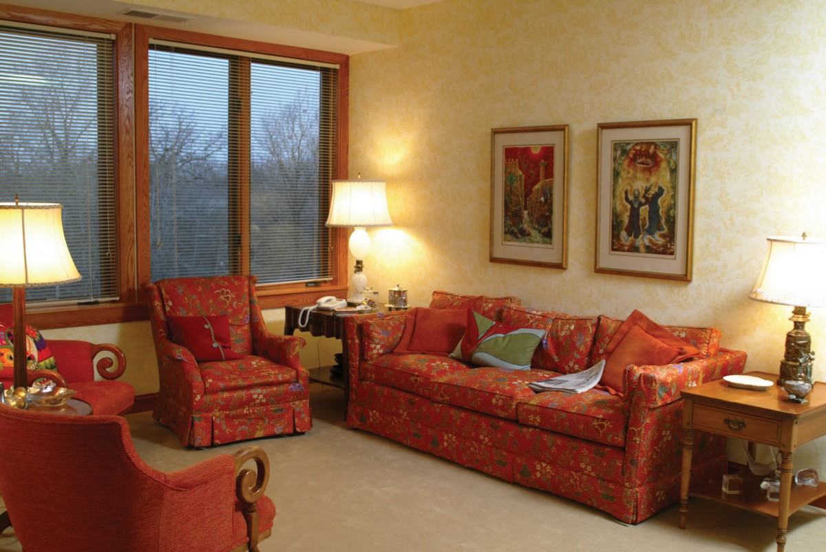 Cozy living room with orange furniture and decorative paintings.
