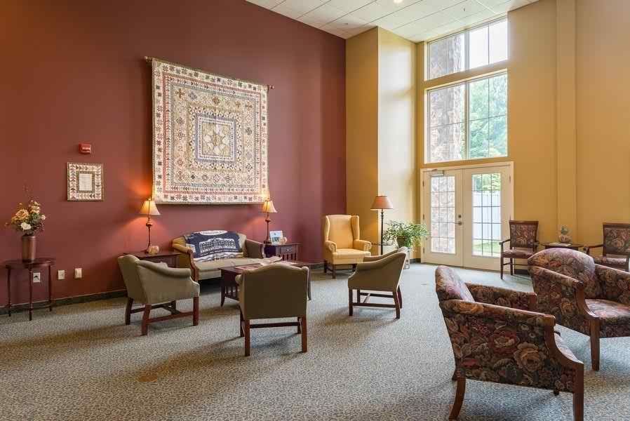 A cozy lobby with comfortable seating and large windows illuminating the space.