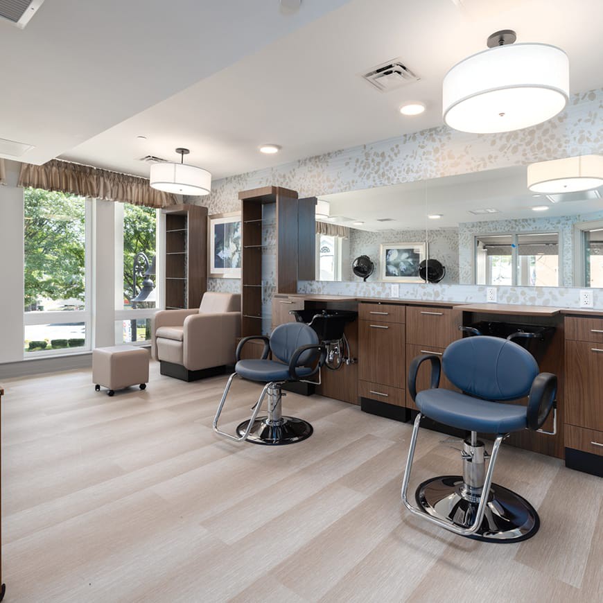 A modern hair salon interior with spacious seating and large mirrors.
