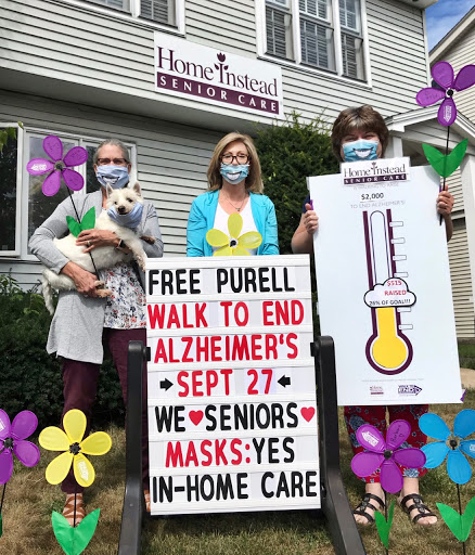Participants promoting the 'Walk to End Alzheimer's' event, emphasizing health safety measures while supporting seniors.