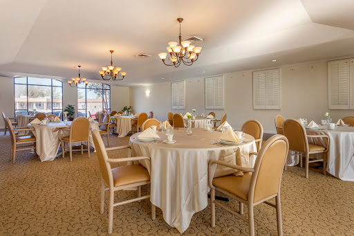 An elegant dining room setup with round tables, soft lighting, and comfortable chairs.