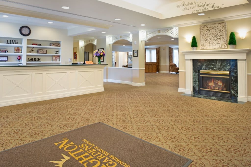 A welcoming hotel lobby with a reception desk and fireplace.