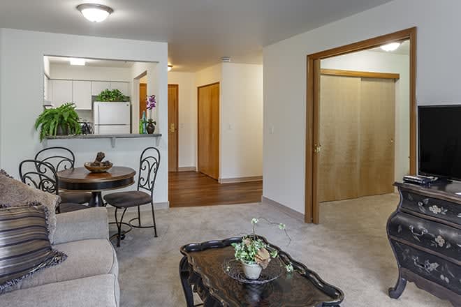 A cozy living room with an open view into the kitchen, featuring comfortable seating and elegant home decor.