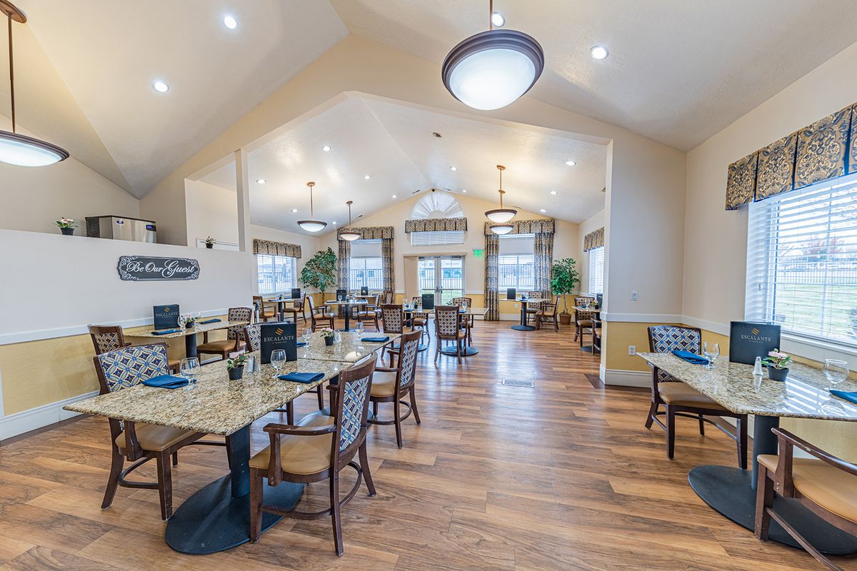 A spacious and modern dining room with elegant tables, chairs, and warm lighting.