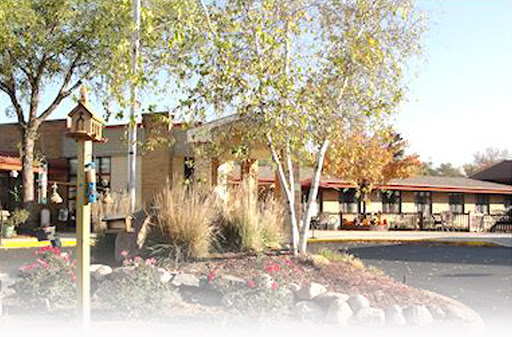 A serene outdoor view featuring a building surrounded by trees and landscaping.