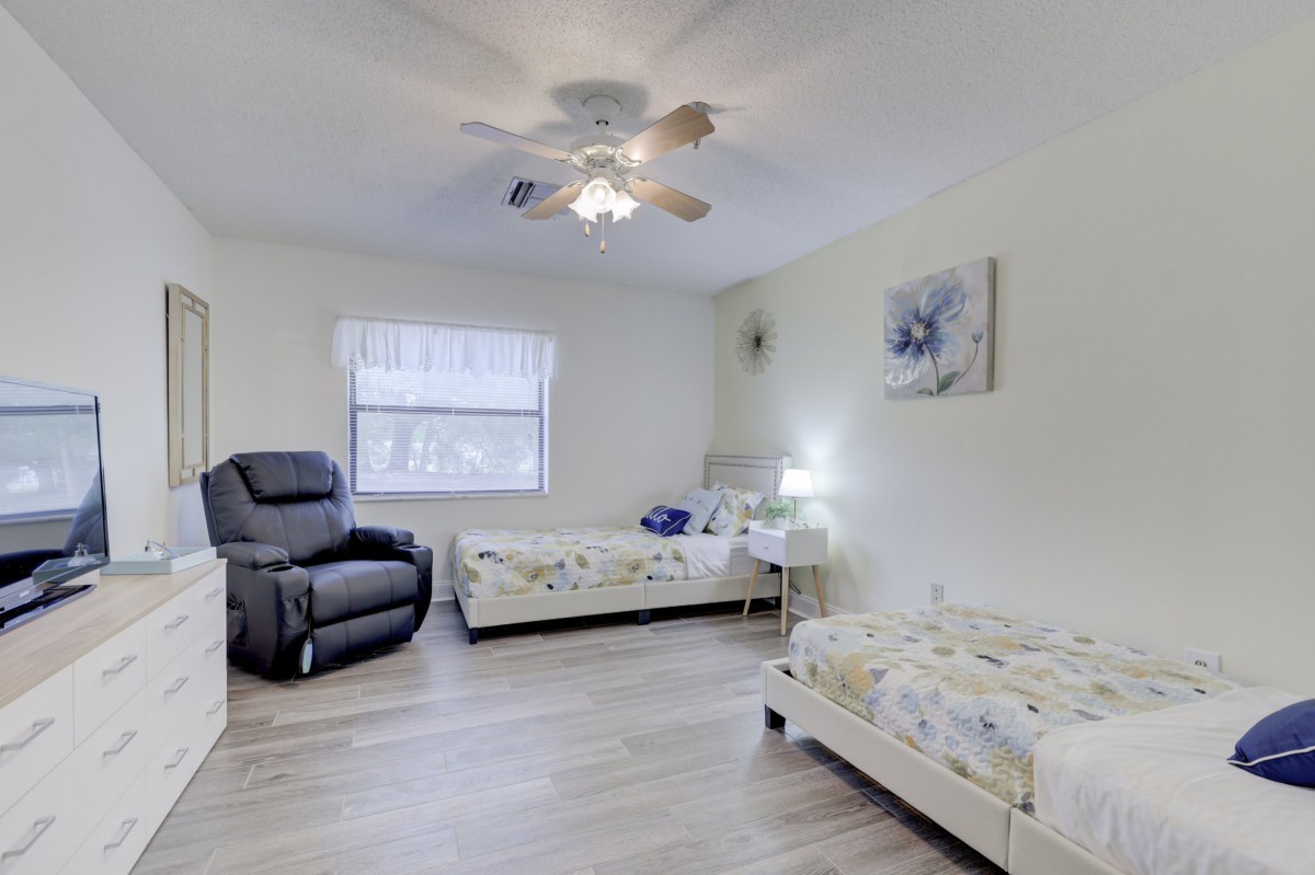 Bright and spacious bedroom with twin beds and a recliner.