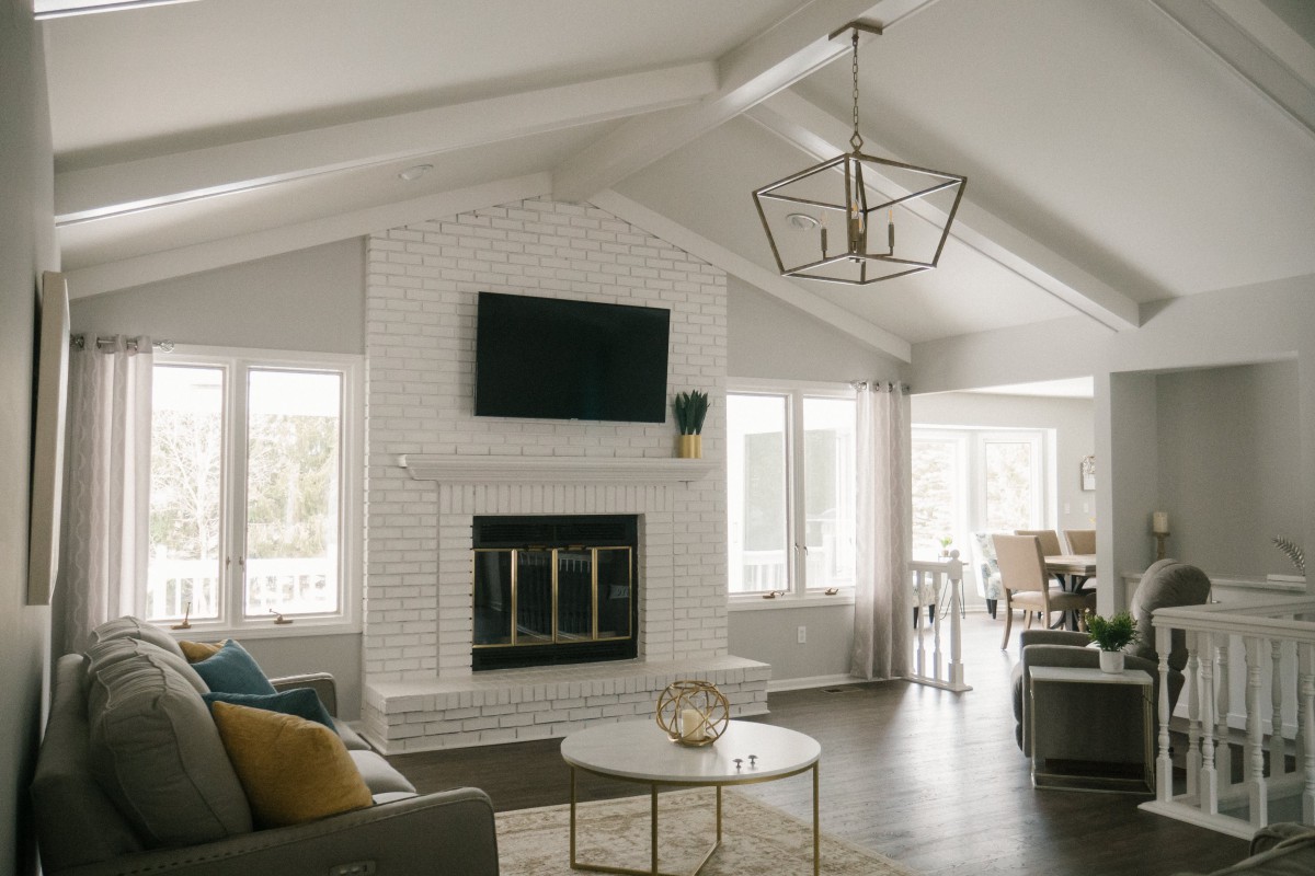 A modern living room with a fireplace, television, and vaulted ceiling.