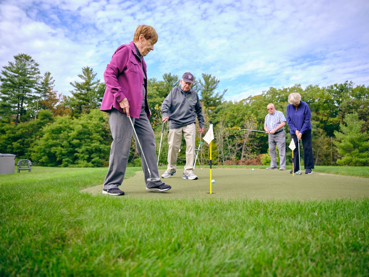 A group of seniors enjoying a game of golf on a sunny day.