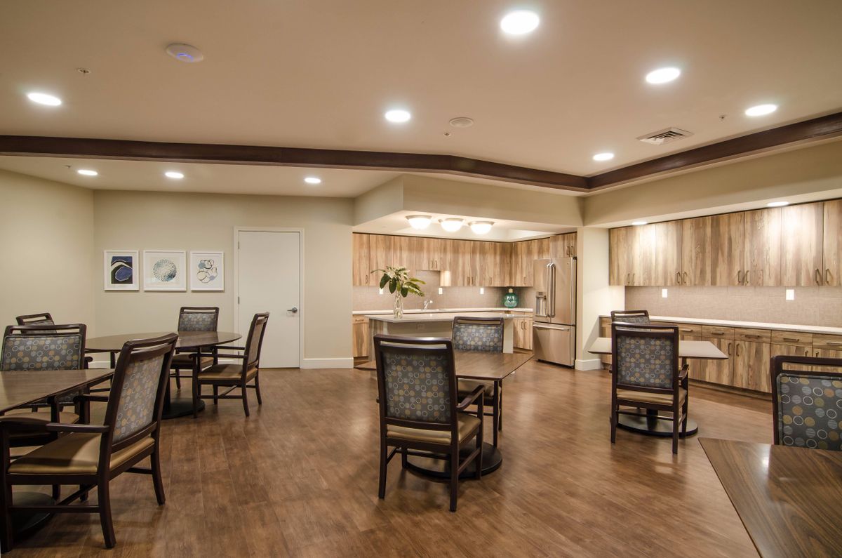 A modern kitchen and dining area with wooden flooring and elegant furnishings.