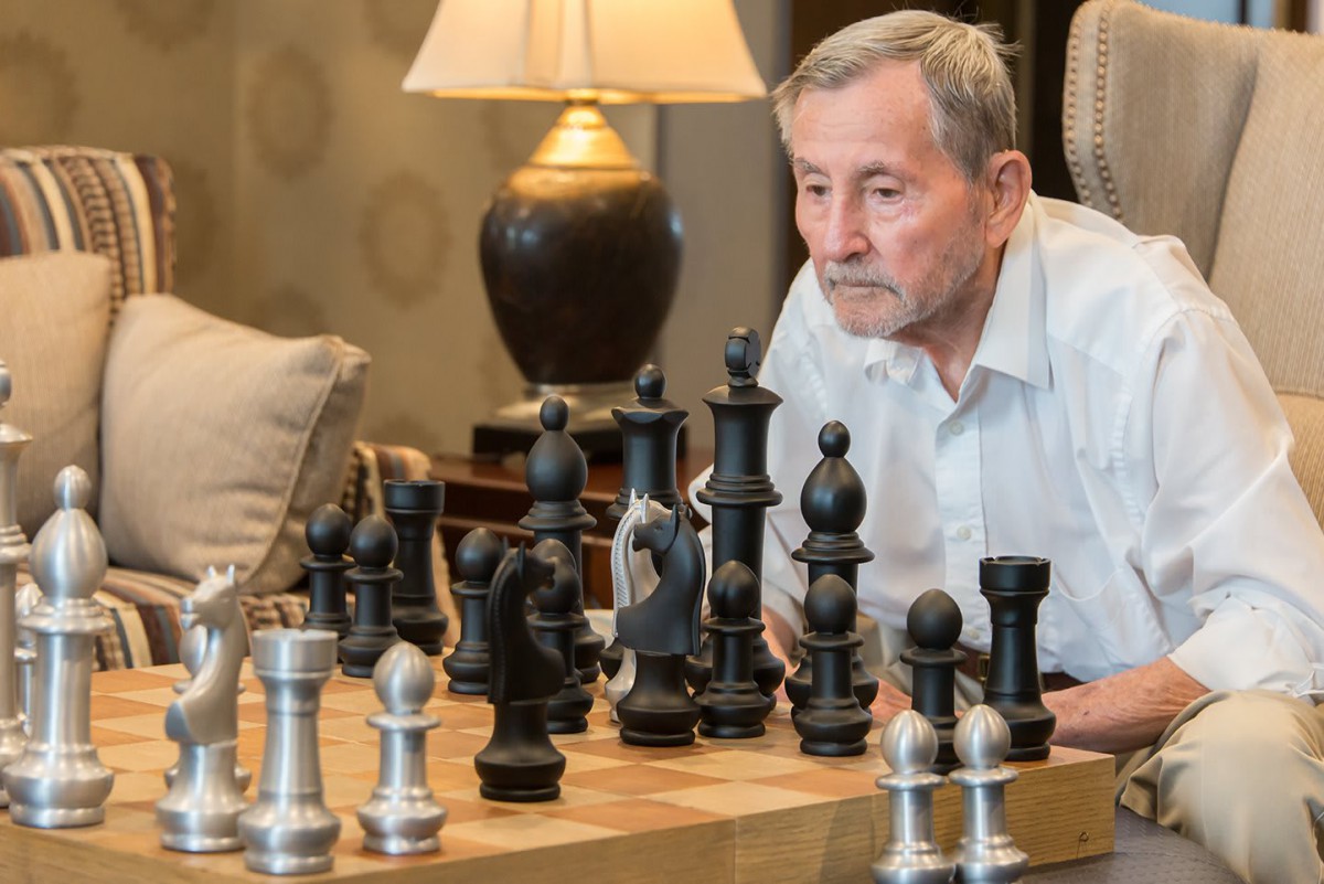 A person deeply focused on a game of chess, contemplating their next move.