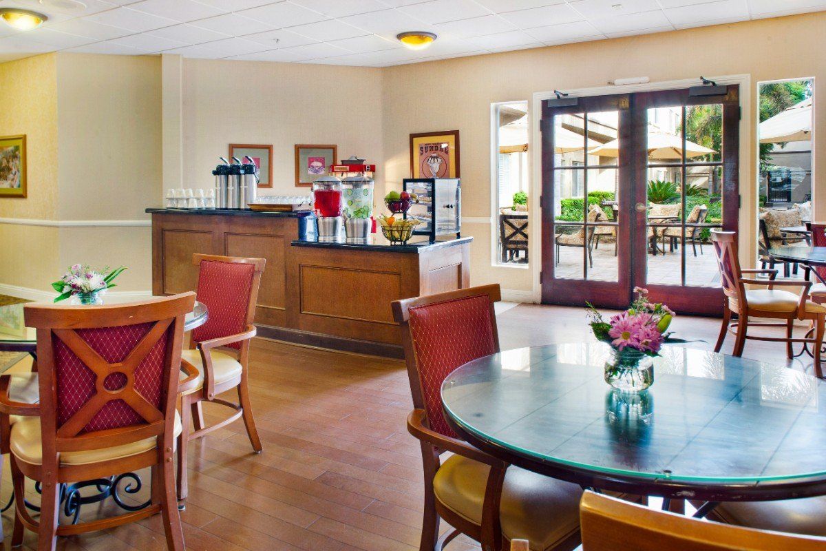 A cozy cafe interior with tables and chairs near a coffee station.