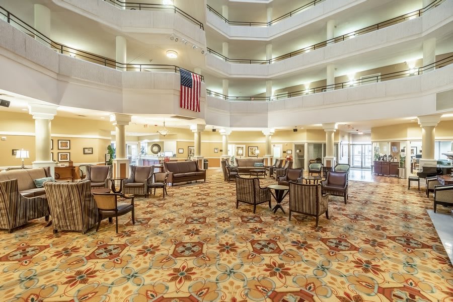 A spacious lobby with an atrium, adorned with elegant furniture and a patterned carpet.