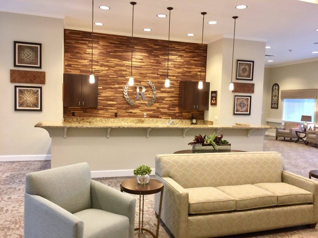 A modern lobby with stylish furniture, pendant lighting, and wood accents.