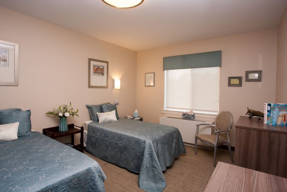 A cozy bedroom with twin beds and soft lighting.