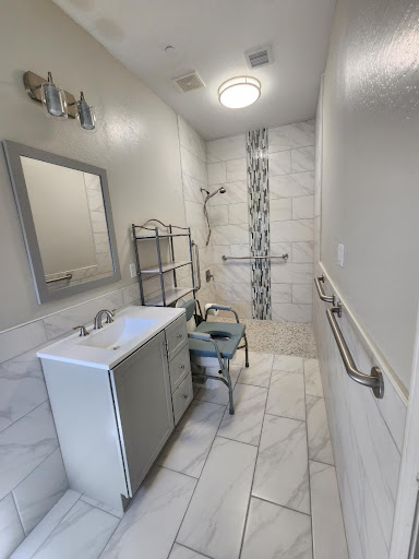 A modern, newly renovated bathroom featuring elegant tile work and accessible fixtures.