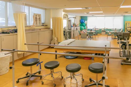 A well-equipped physical therapy room featuring various medical tools and seating arrangements.