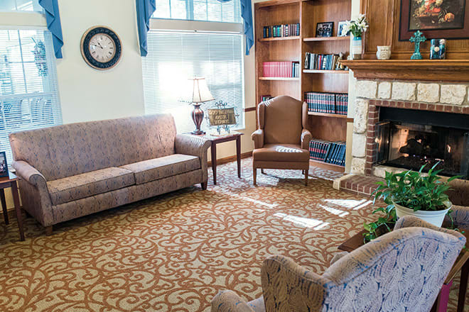 A cozy living room with comfortable seating, a bookshelf, and a fireplace.
