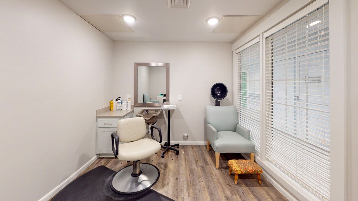A modern and minimalist salon interior with chairs, a mirror, and a hair dryer.
