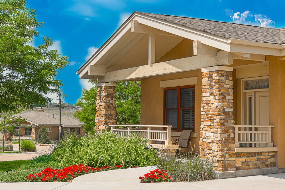 A charming house with a welcoming porch and beautiful landscaping under a clear blue sky.
