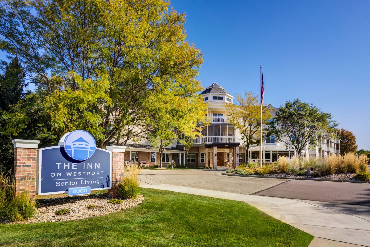The exterior of The Inn with surrounding trees and a clear blue sky.