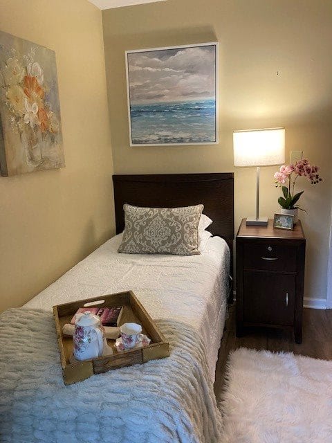A cozy bedroom with a single bed, nightstand, and decorative artwork.