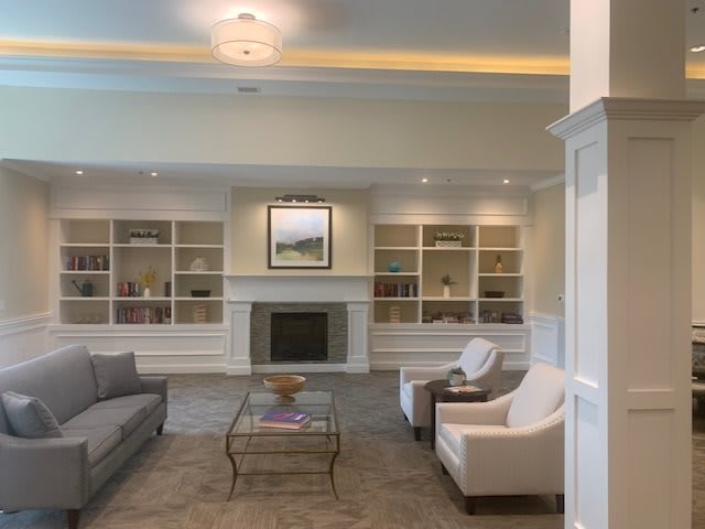 A cozy living room with a fireplace, bookshelves, and comfortable seating arrangements.