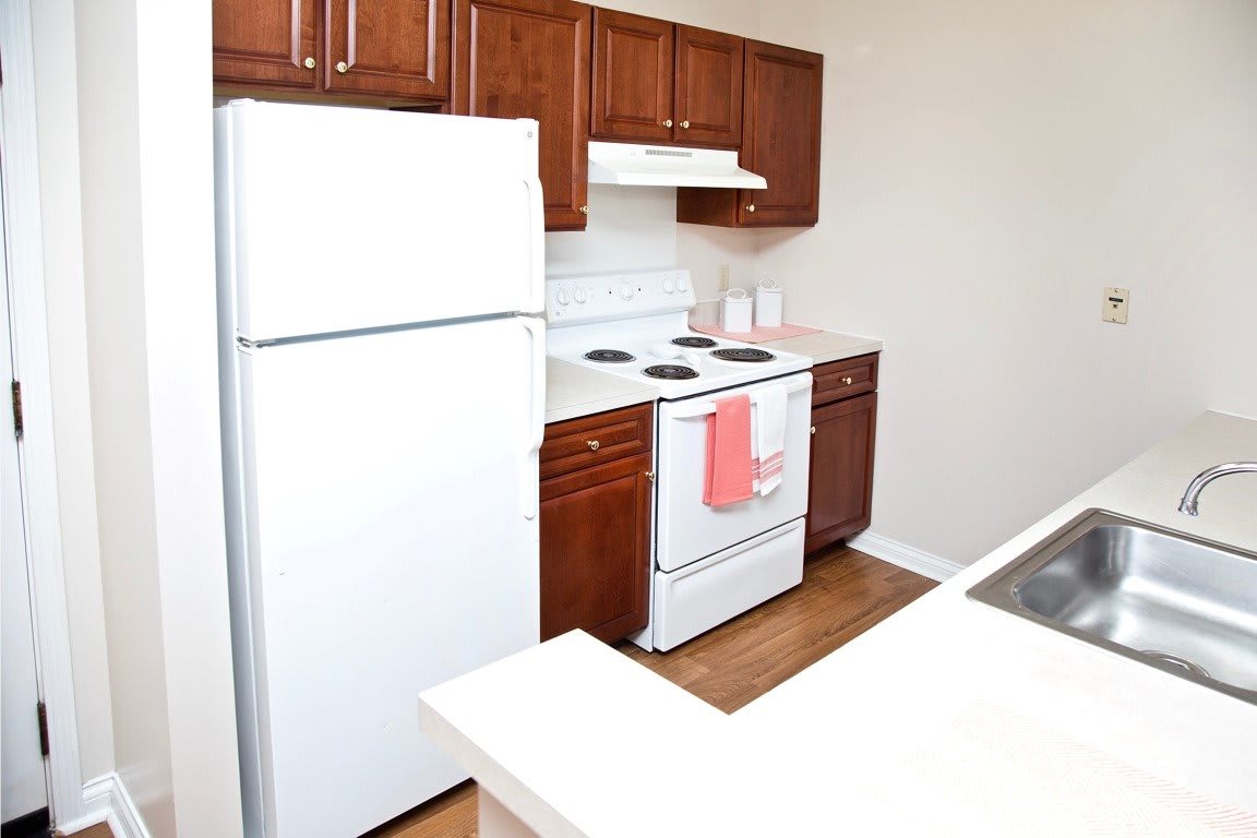 A modern kitchen with wooden cabinets and white appliances.