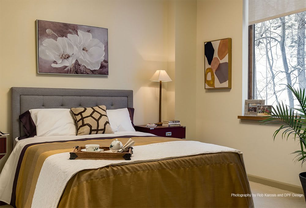 A cozy bedroom interior with elegant decor and a tray on the bed.