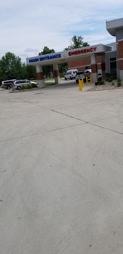 A view of a parking lot with several vehicles near a building entrance.