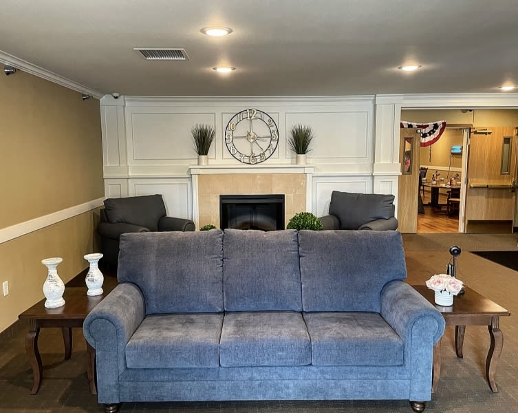 A cozy living room with a blue sofa, fireplace, and decorative elements.