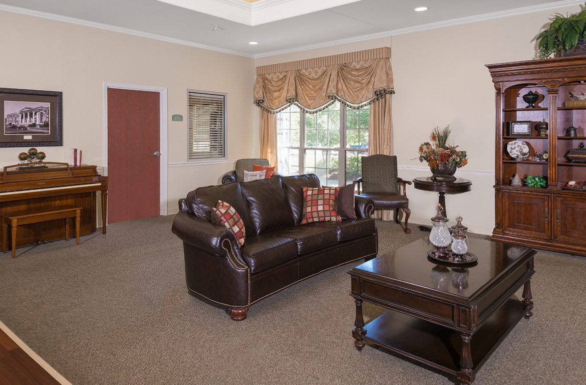 A traditionally decorated living room with a leather sofa, armchairs, and a coffee table.