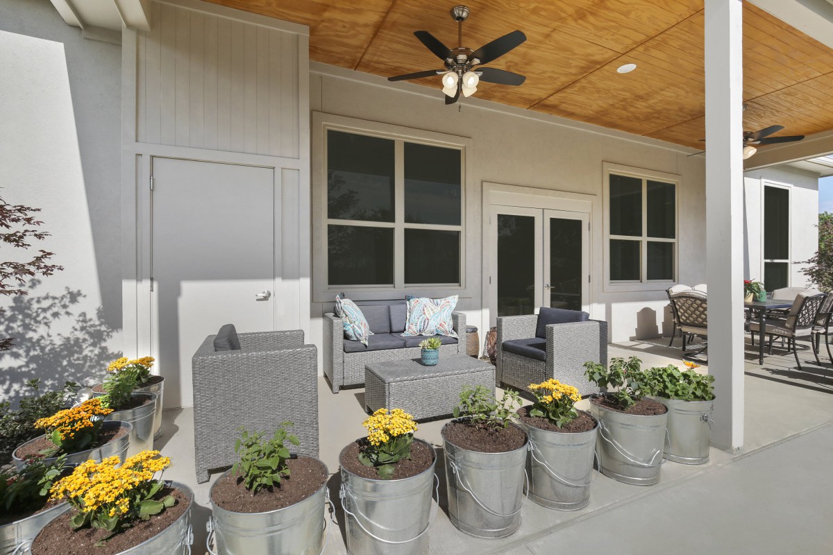 A cozy patio with comfortable outdoor seating and decorative flower pots.