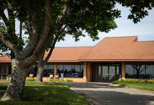 A peaceful view of a brick building surrounded by greenery.