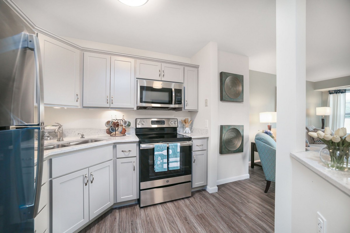 A modern kitchen featuring stainless steel appliances and white cabinetry.