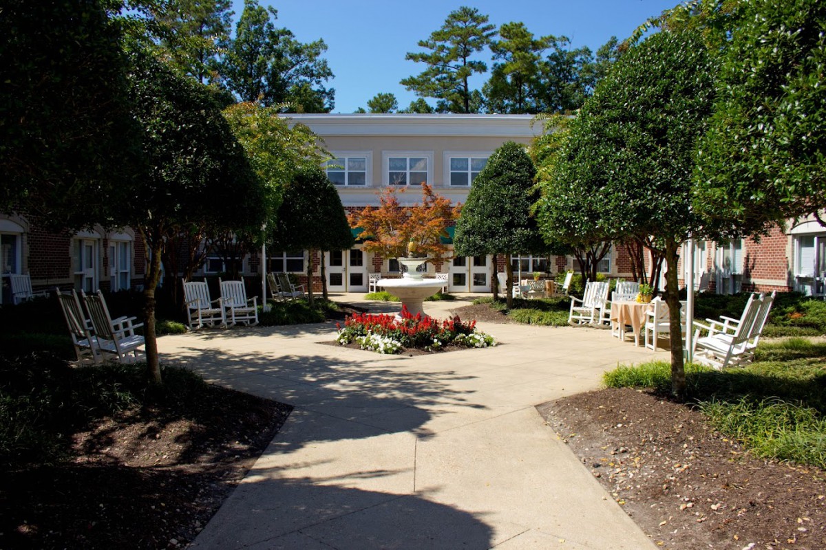 A beautifully landscaped courtyard with a garden and pathway leading to a building.
