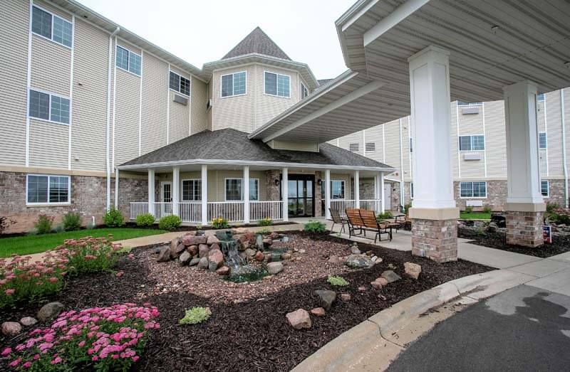 A modern building with landscaped entrance and covered walkway.