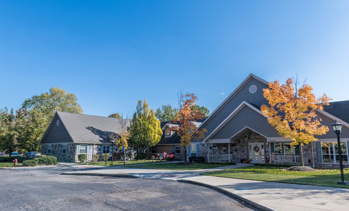 A suburban residential building surrounded by trees in autumn.