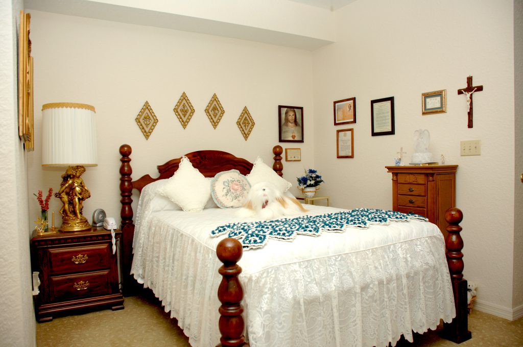 A cozy bedroom with traditional furnishings and decorative wall art.