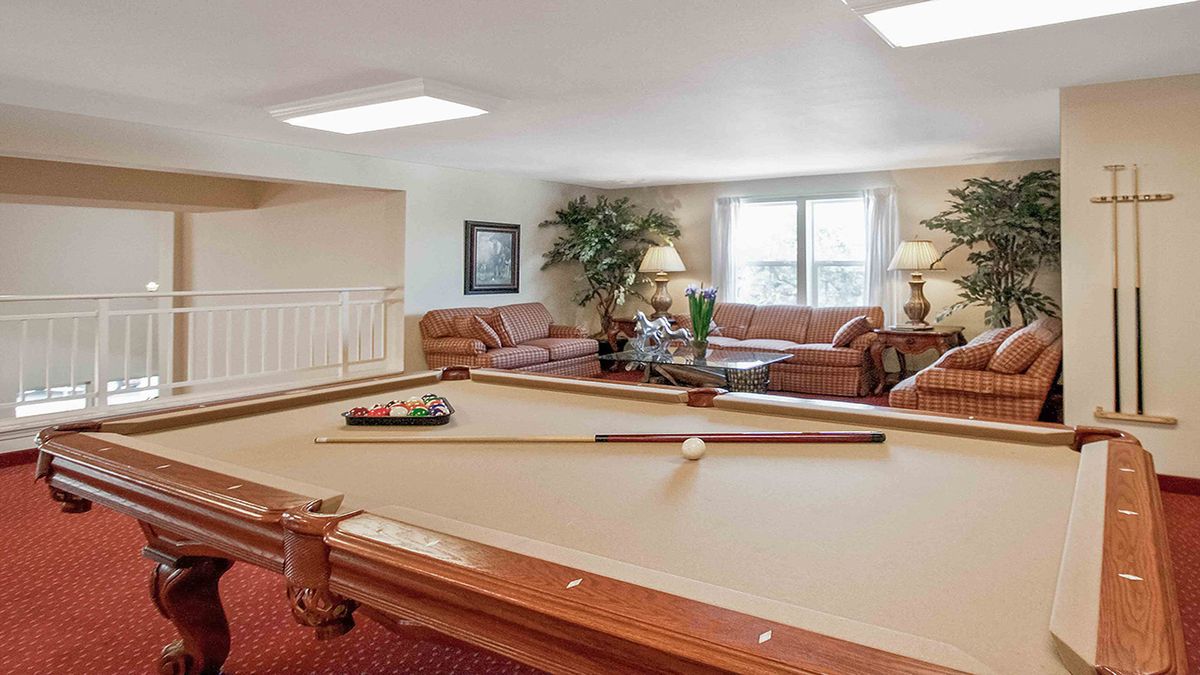 A cozy living room with a billiard table and comfortable sofas.