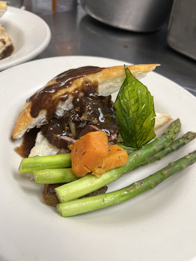 A beautifully plated dish featuring tender meat, vibrant vegetables, and a rich sauce.